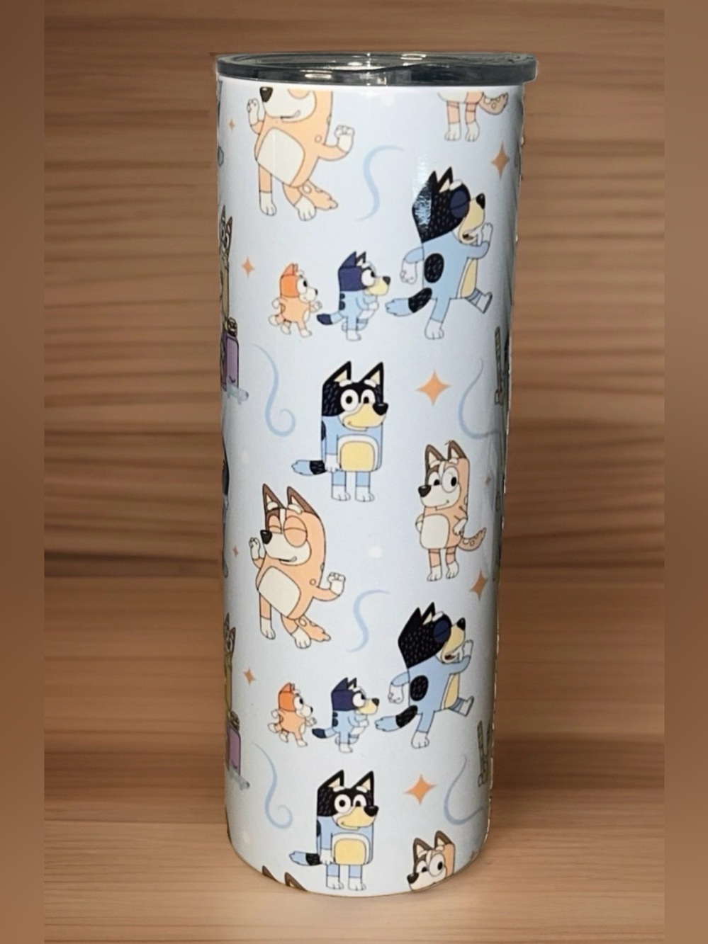 The Bluey Cartoon Blue Tumbler is a 20 oz skinny travel cup mug featuring the po